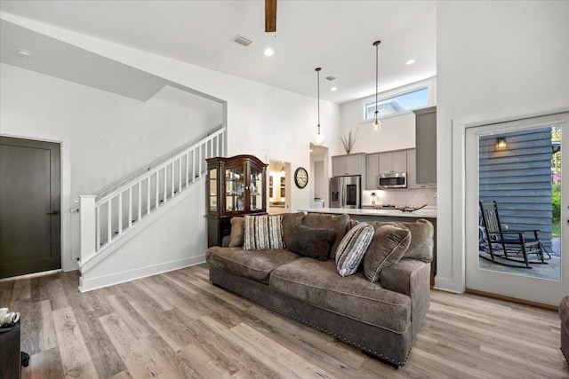 living room featuring a high ceiling and light hardwood / wood-style floors