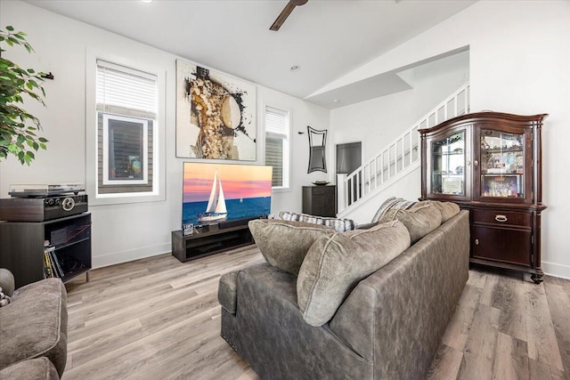 living room with lofted ceiling, light hardwood / wood-style flooring, and ceiling fan