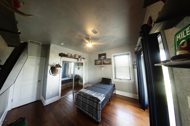 bedroom featuring ceiling fan, a textured ceiling, a closet, and dark hardwood / wood-style flooring