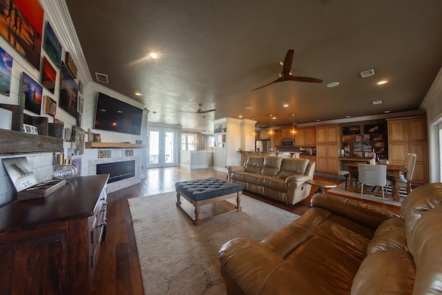 living room with crown molding, ceiling fan, and hardwood / wood-style flooring