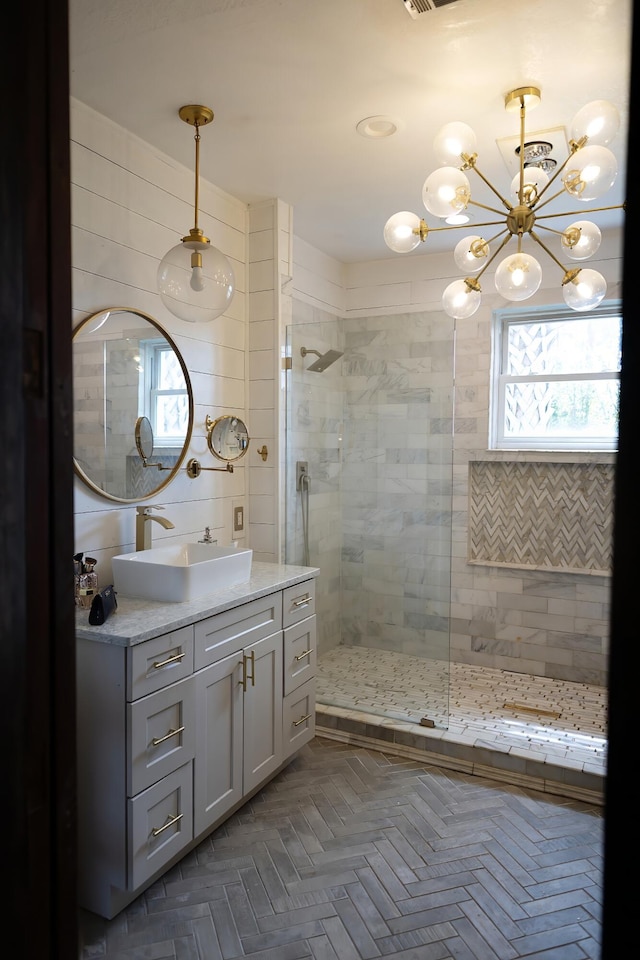 bathroom with vanity, parquet flooring, and tiled shower