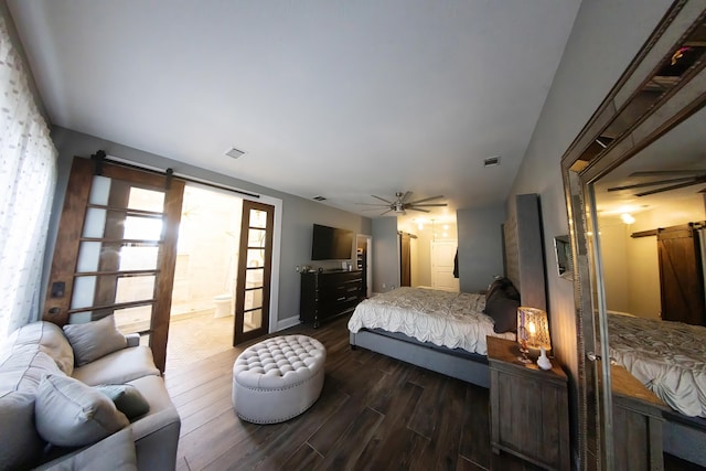 bedroom with ceiling fan, dark wood-type flooring, connected bathroom, and a barn door