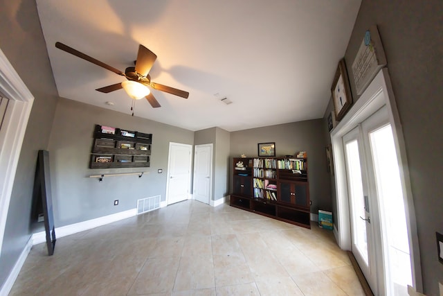 living room featuring light tile patterned floors and ceiling fan