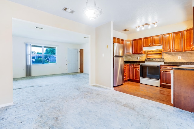 kitchen featuring sink, light hardwood / wood-style flooring, white electric range, stainless steel refrigerator, and decorative backsplash