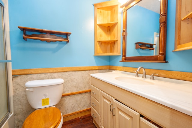 bathroom with a shower with shower door, hardwood / wood-style flooring, vanity, and toilet