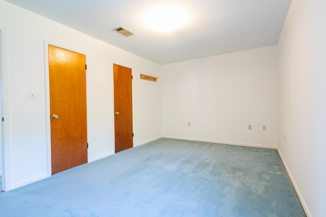 unfurnished bedroom featuring carpet and a textured ceiling