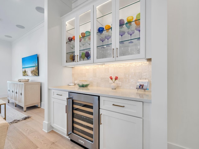 218 White Cottage Rd, Santa Rosa Beach, FL 32459 - bar with light wood-type flooring, ornamental molding, a bar, decorative backsplash, and beverage cooler