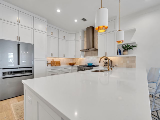 218 White Cottage Rd, Santa Rosa Beach, FL 32459 - kitchen with freestanding refrigerator, a peninsula, wall chimney range hood, open shelves, and a sink