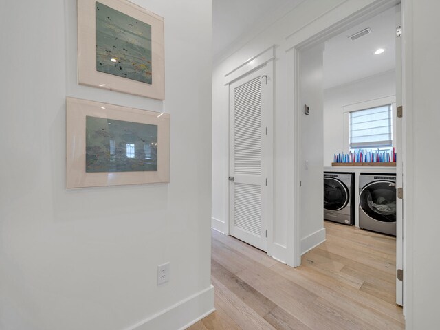 hall featuring washing machine and clothes dryer and light hardwood / wood-style flooring