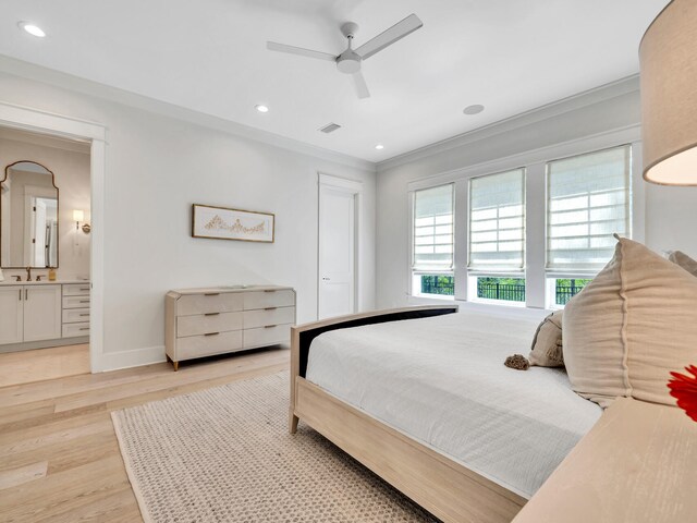 bedroom featuring ceiling fan, light hardwood / wood-style floors, crown molding, and ensuite bathroom