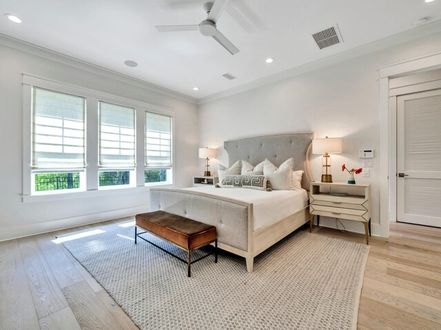 bedroom featuring light wood-type flooring, ceiling fan, and ornamental molding