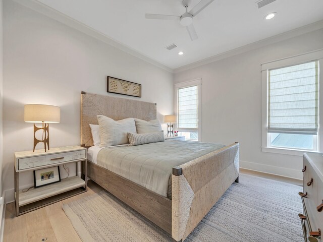 bedroom featuring ceiling fan, crown molding, and light hardwood / wood-style floors