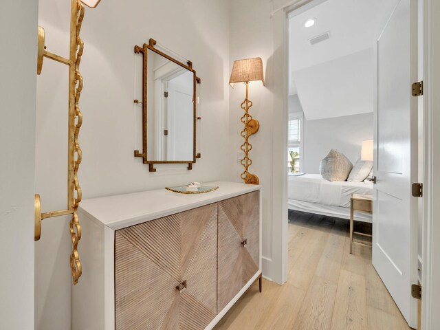 bathroom featuring hardwood / wood-style floors, vanity, and vaulted ceiling