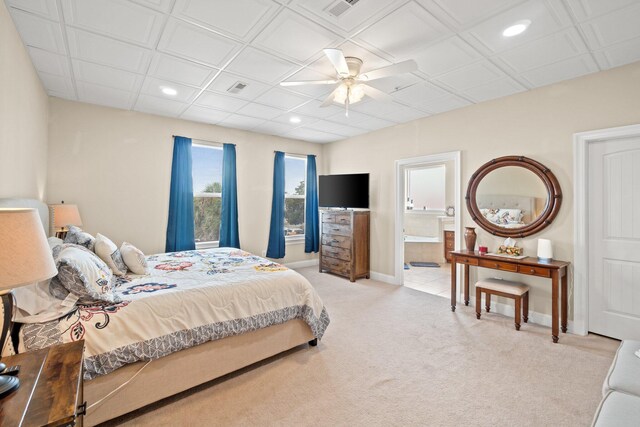 bedroom featuring ensuite bathroom, ceiling fan, and light colored carpet