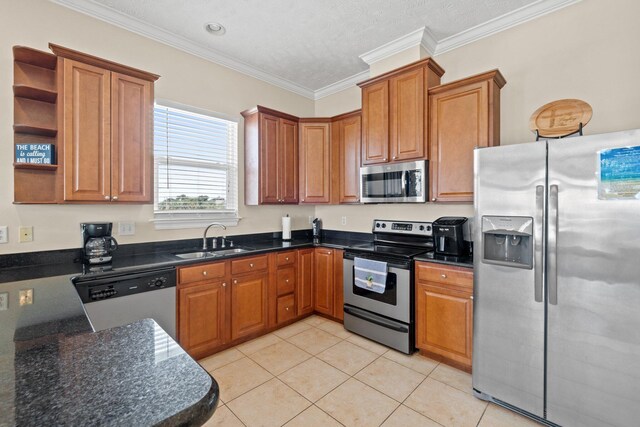 kitchen with appliances with stainless steel finishes, light tile patterned floors, a textured ceiling, crown molding, and sink