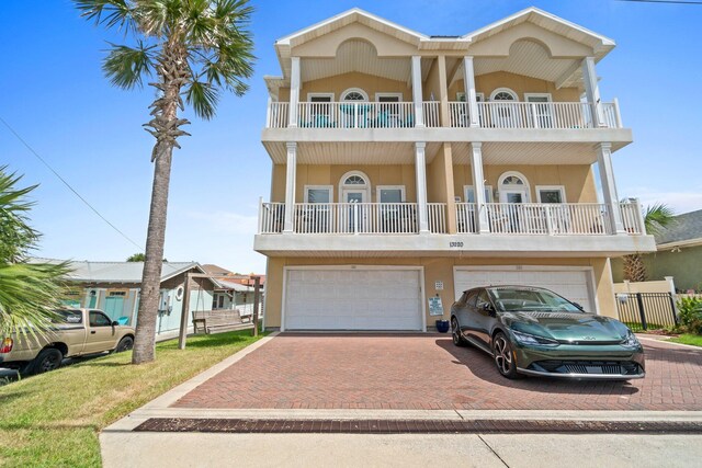 coastal inspired home featuring a balcony and a garage