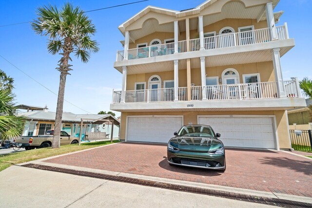 coastal inspired home with a balcony and a garage