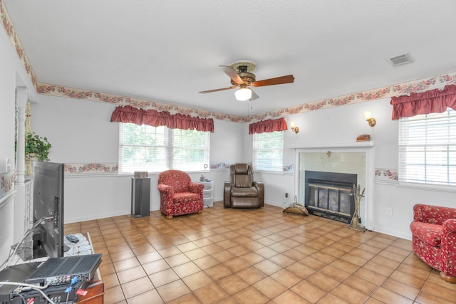 interior space featuring ceiling fan and a tile fireplace