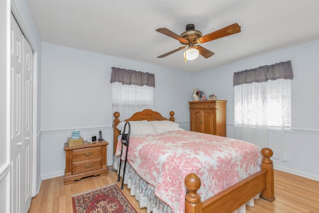 bedroom featuring ceiling fan, a closet, and light hardwood / wood-style floors