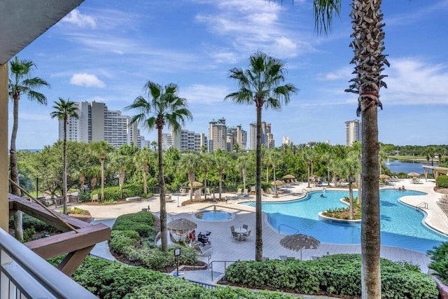 view of swimming pool featuring a water view and a patio