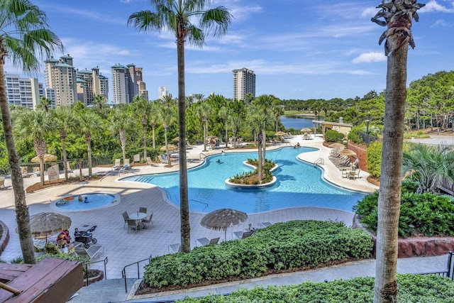 view of swimming pool featuring a water view and a patio area