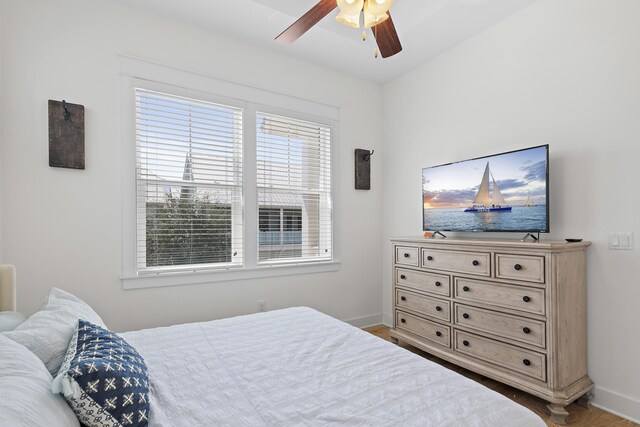 bedroom featuring ceiling fan, wood-type flooring, and multiple windows