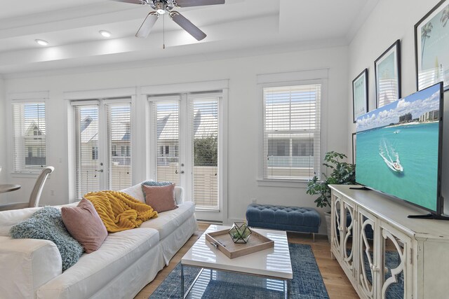 living room with ceiling fan, french doors, light hardwood / wood-style floors, and crown molding