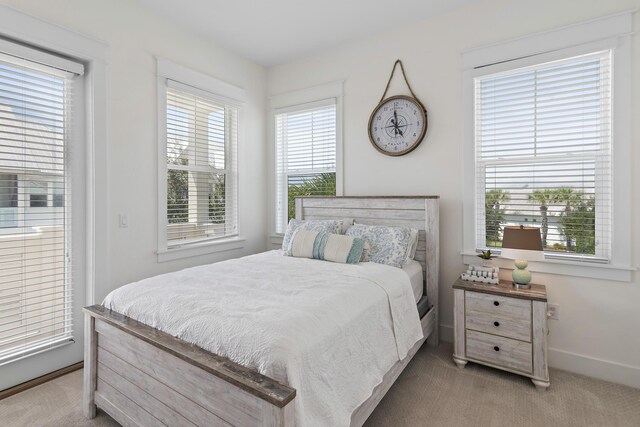 bedroom with light colored carpet and multiple windows