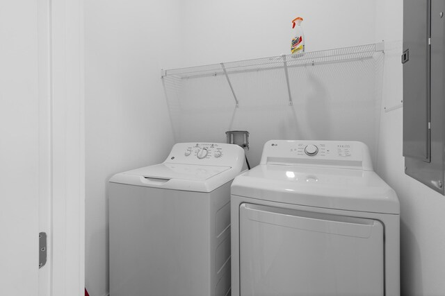 washroom with washer and clothes dryer and electric panel