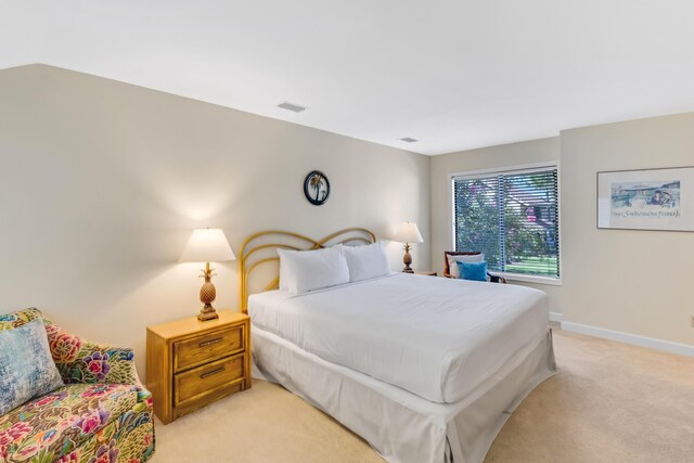 bedroom featuring light colored carpet and lofted ceiling