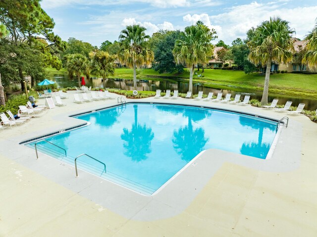 view of pool featuring a water view and a patio area