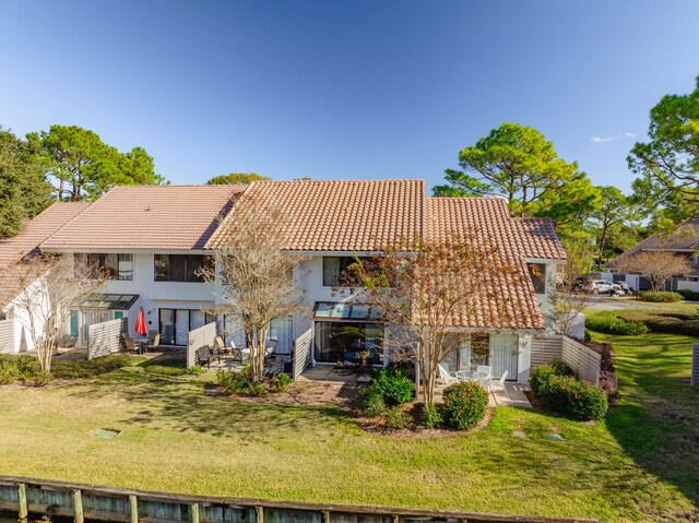 back of property featuring a yard and a patio