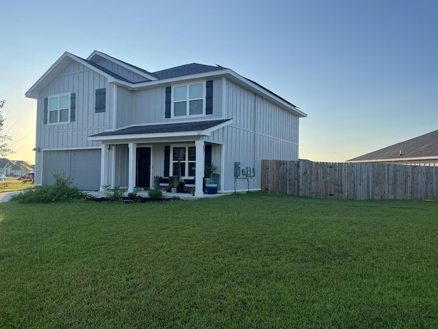 back house at dusk featuring a garage and a yard