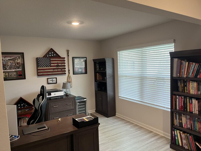 home office with light hardwood / wood-style floors