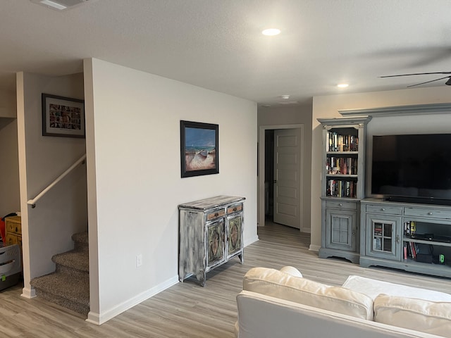 living room featuring light hardwood / wood-style floors and ceiling fan