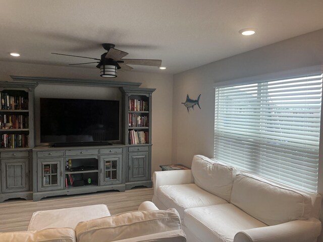 living room with ceiling fan and light hardwood / wood-style flooring