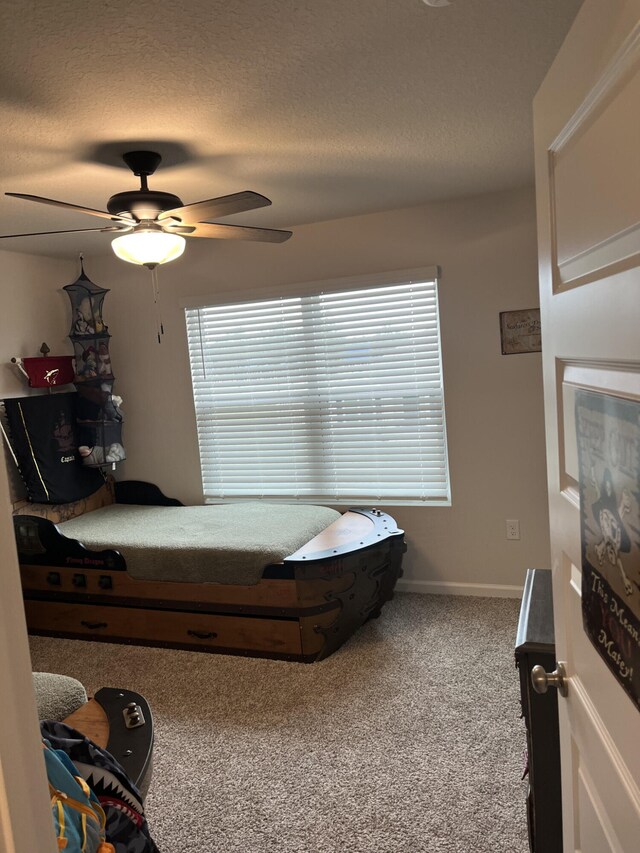 bedroom featuring ceiling fan, a textured ceiling, and carpet