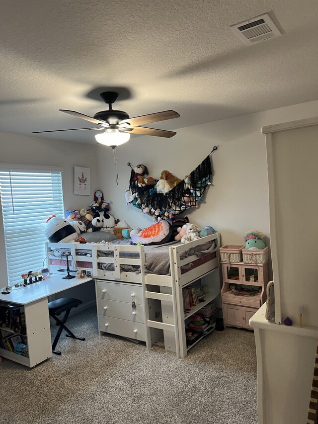 bedroom with carpet, ceiling fan, and a textured ceiling