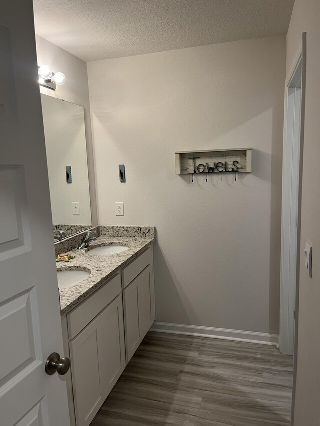 bathroom featuring a textured ceiling, vanity, and hardwood / wood-style flooring