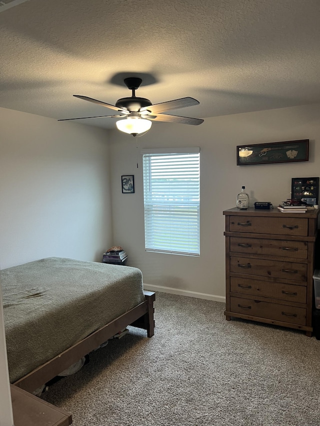 carpeted bedroom featuring ceiling fan and a textured ceiling