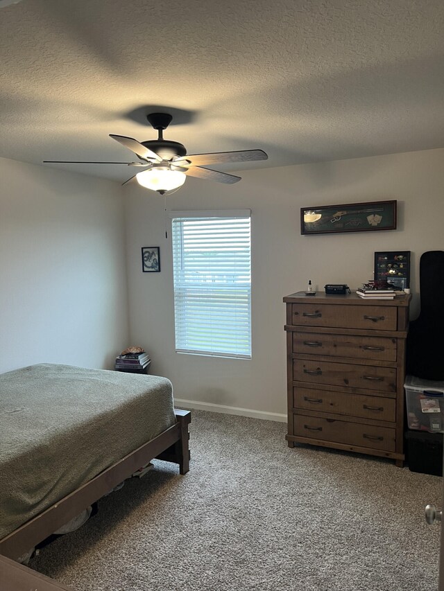 bedroom featuring a textured ceiling, ceiling fan, and carpet floors