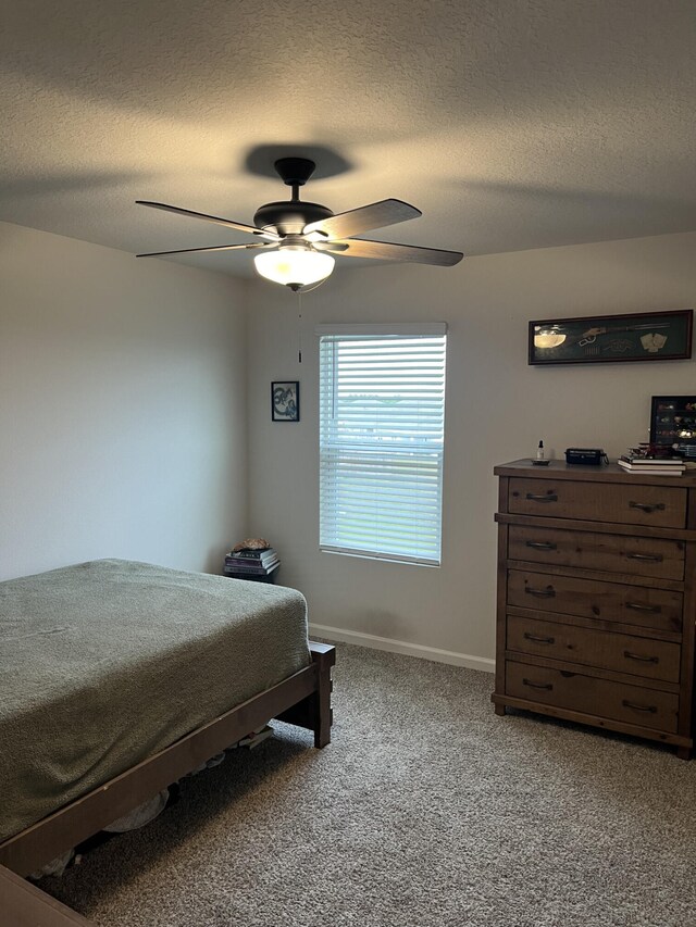 bedroom with carpet, ceiling fan, and a textured ceiling