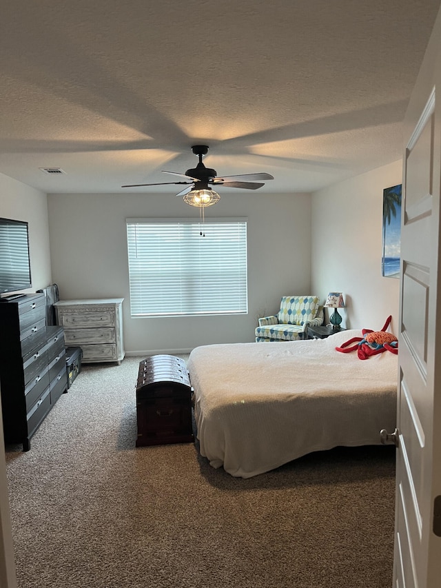 carpeted bedroom featuring a textured ceiling and ceiling fan