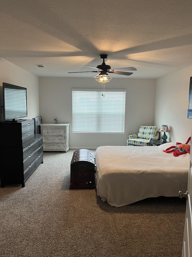 bedroom featuring ceiling fan, carpet flooring, and a textured ceiling