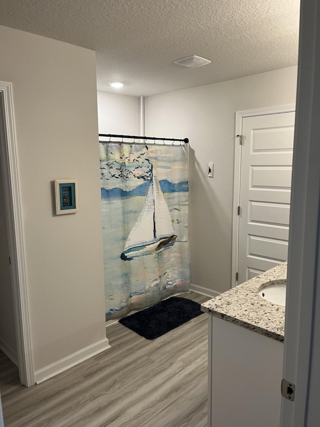 bathroom featuring vanity, hardwood / wood-style floors, and a textured ceiling