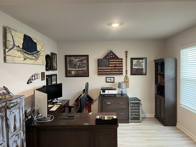 office area with a textured ceiling and light hardwood / wood-style flooring