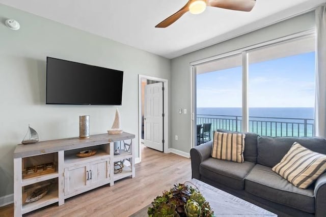 living room featuring a water view, ceiling fan, and light hardwood / wood-style flooring