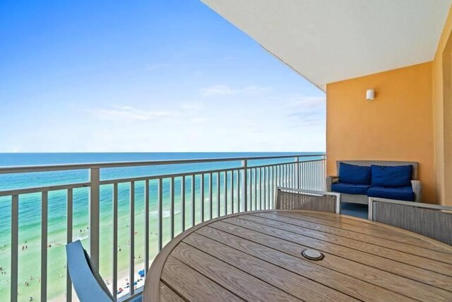 balcony featuring a water view and a view of the beach