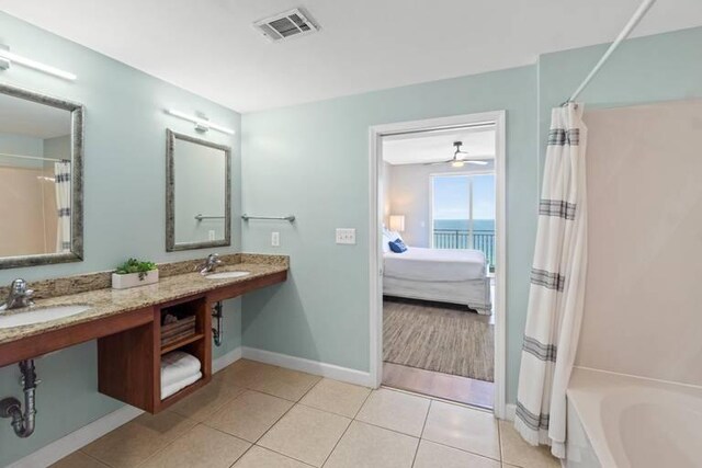 bathroom featuring a water view, vanity, plus walk in shower, and tile patterned floors