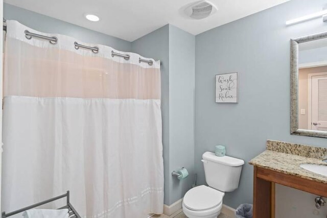 bathroom featuring walk in shower, vanity, and toilet